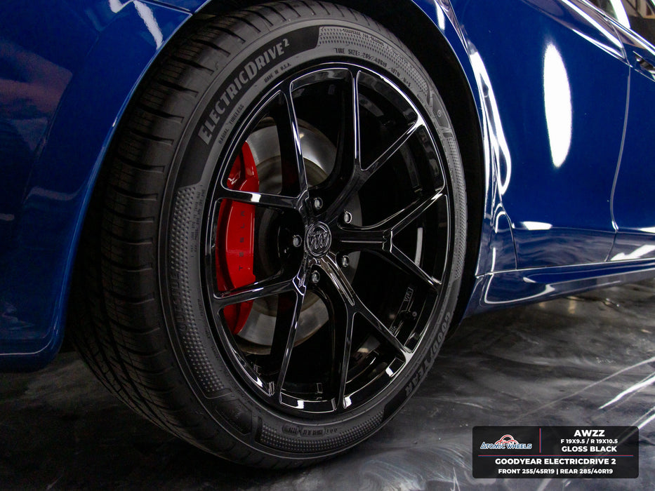 Rear wheel close-up of blue Tesla Model S Plaid with gloss black AWZZ forged wheels, 19x9.5 front and 19x10.5 rear, and Goodyear ElectricDrive 2 tires